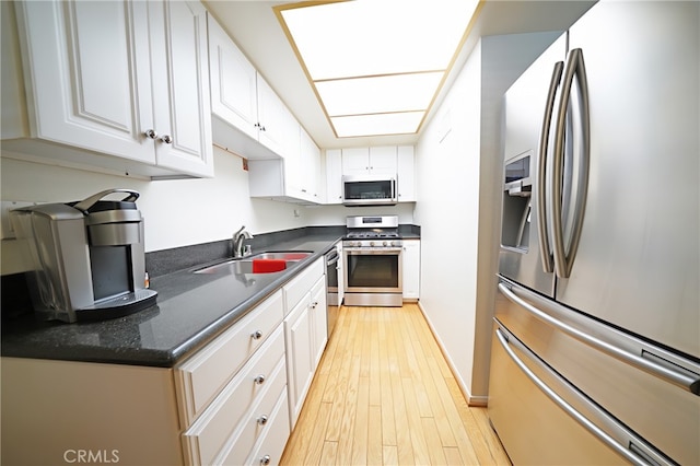18560 Vanowen St Unit 27, Reseda, CA 91335 - kitchen with stainless steel appliances, white cabinets, and light wood-style flooring