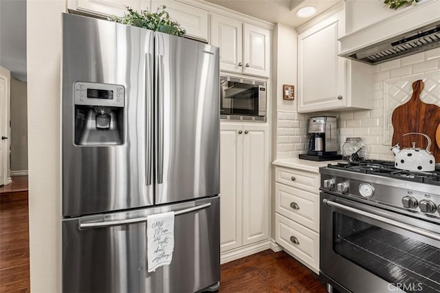 20072 Mural Cir, Huntington Beach, CA 92646 - kitchen featuring appliances with stainless steel finishes, premium range hood, tasteful backsplash, and dark wood-style flooring