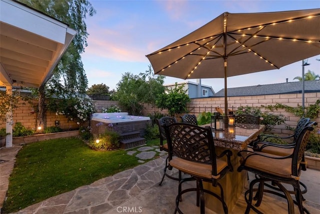 20072 Mural Cir, Huntington Beach, CA 92646 - patio terrace at dusk with a hot tub, a fenced backyard, a patio, and outdoor dining space