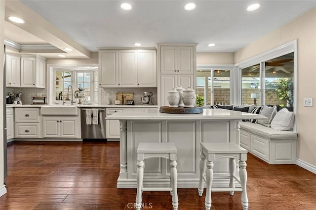 20072 Mural Cir, Huntington Beach, CA 92646 - kitchen featuring dishwasher, light countertops, decorative backsplash, a breakfast bar, and recessed lighting