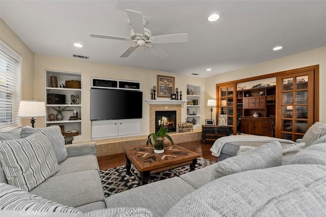 20072 Mural Cir, Huntington Beach, CA 92646 - living area featuring built in shelves, wood finished floors, ceiling fan, a tile fireplace, and recessed lighting