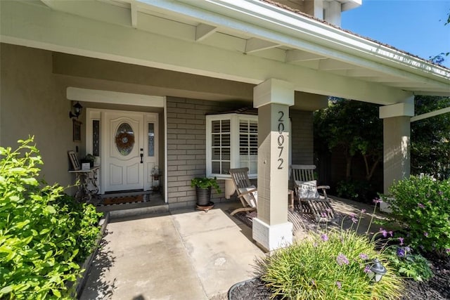 20072 Mural Cir, Huntington Beach, CA 92646 - doorway to property featuring covered porch and brick siding