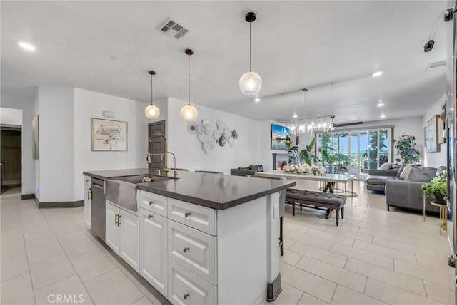 40569 Koa Ct, Temecula, CA 92591 - kitchen featuring dark countertops, open floor plan, stainless steel dishwasher, light tile patterned floors, and an island with sink