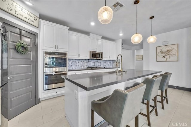 40569 Koa Ct, Temecula, CA 92591 - kitchen featuring stainless steel appliances, dark countertops, light tile patterned flooring, decorative backsplash, and recessed lighting