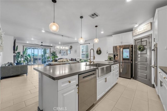 40569 Koa Ct, Temecula, CA 92591 - kitchen featuring appliances with stainless steel finishes, dark countertops, open floor plan, recessed lighting, and an island with sink