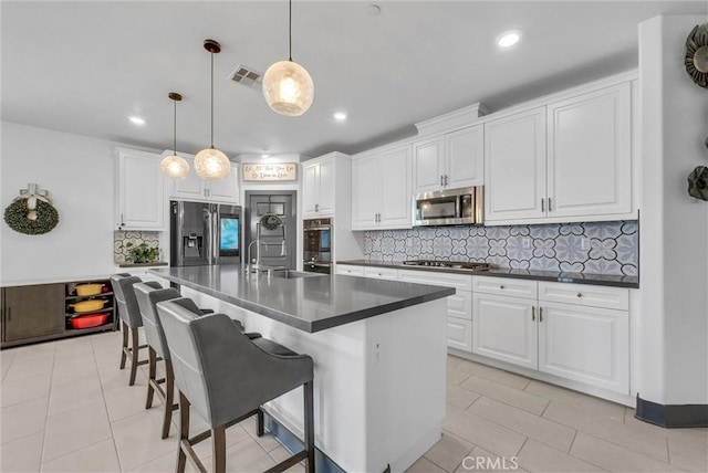40569 Koa Ct, Temecula, CA 92591 - kitchen with appliances with stainless steel finishes, dark countertops, tasteful backsplash, white cabinets, and recessed lighting