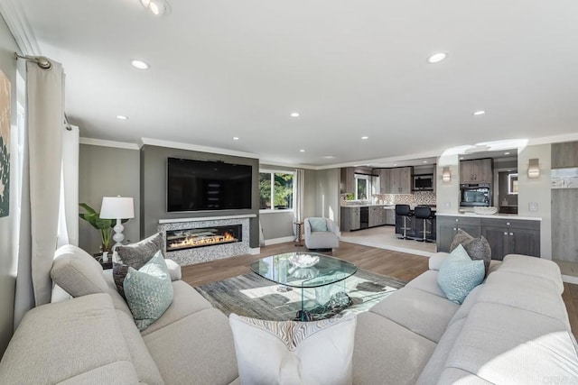 3526 Ticonderoga St, San Diego, CA 92117 - living room with ornamental molding, a glass covered fireplace, light wood-style floors, and recessed lighting