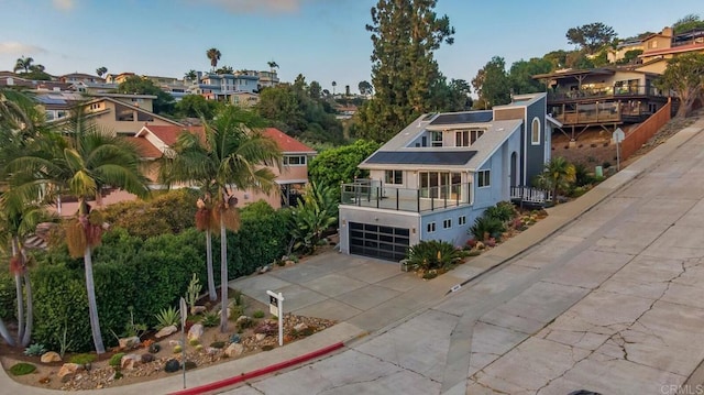 3526 Ticonderoga St, San Diego, CA 92117 - view of front of house featuring roof mounted solar panels, driveway, stucco siding, an attached garage, and a residential view