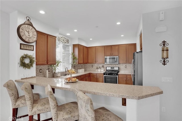 1405 Santa Victoria Rd Unit 2, Chula Vista, CA 91913 - kitchen with appliances with stainless steel finishes, a peninsula, backsplash, recessed lighting, and a breakfast bar area