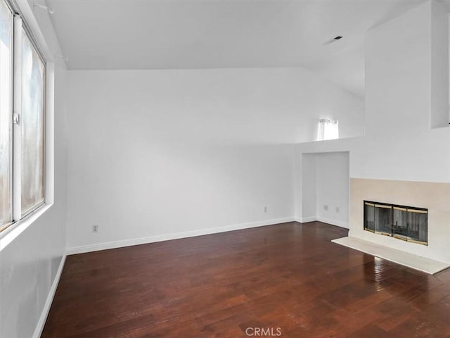 37453 56th St E, Palmdale, CA 93552 - unfurnished living room featuring vaulted ceiling, wood finished floors, and a glass covered fireplace