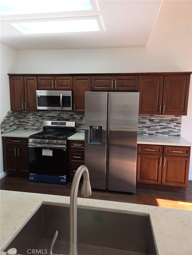37453 56th St E, Palmdale, CA 93552 - kitchen featuring stainless steel appliances, decorative backsplash, dark wood-style floors, and dark brown cabinetry