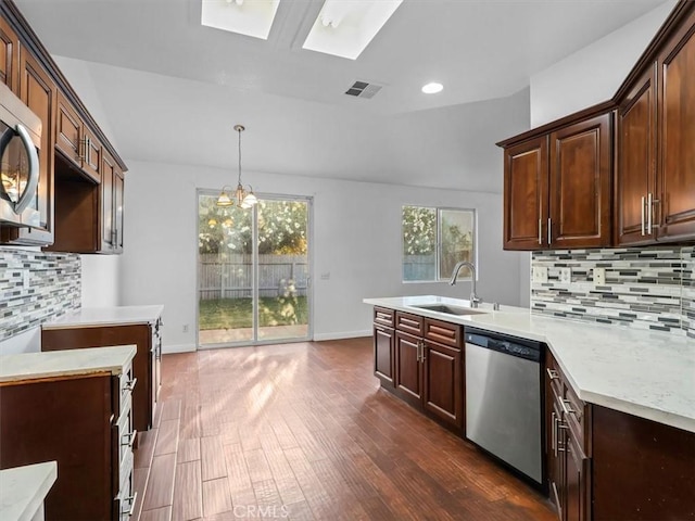 37453 56th St E, Palmdale, CA 93552 - kitchen with appliances with stainless steel finishes, backsplash, a peninsula, light countertops, and dark wood-style flooring