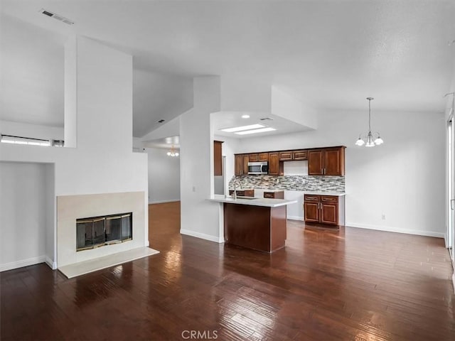 37453 56th St E, Palmdale, CA 93552 - unfurnished living room with a chandelier, lofted ceiling, dark wood finished floors, and a glass covered fireplace
