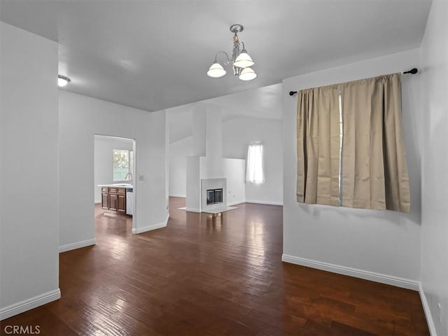 37453 56th St E, Palmdale, CA 93552 - unfurnished living room with a chandelier, dark wood-style floors, and a glass covered fireplace