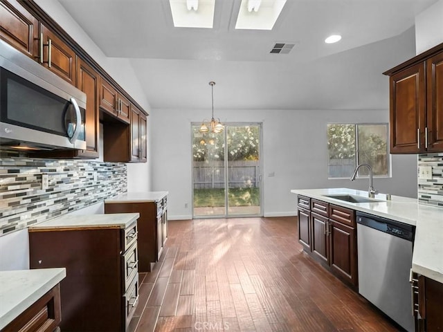 37453 56th St E, Palmdale, CA 93552 - kitchen with stainless steel appliances, light countertops, decorative backsplash, dark wood-style flooring, and a chandelier