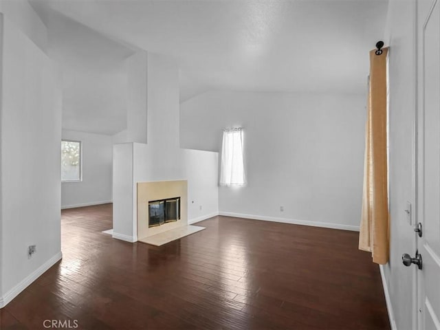 37453 56th St E, Palmdale, CA 93552 - unfurnished living room with vaulted ceiling, dark wood-style floors, and a fireplace with flush hearth