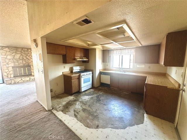 30001 Caddy Ln, Tehachapi, CA 93561 - kitchen with white appliances, a textured ceiling, under cabinet range hood, light countertops, and brown cabinetry