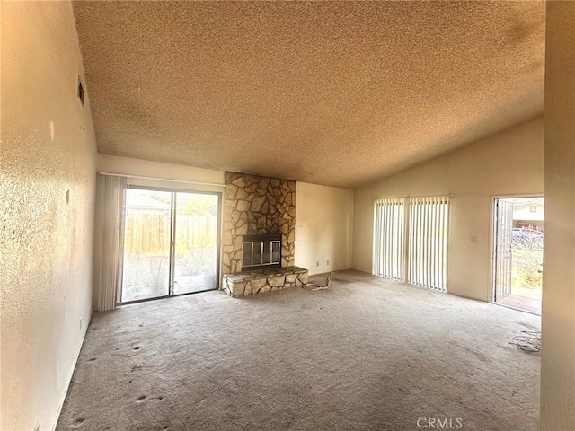 30001 Caddy Ln, Tehachapi, CA 93561 - unfurnished living room featuring carpet flooring, a textured ceiling, plenty of natural light, a fireplace, and vaulted ceiling