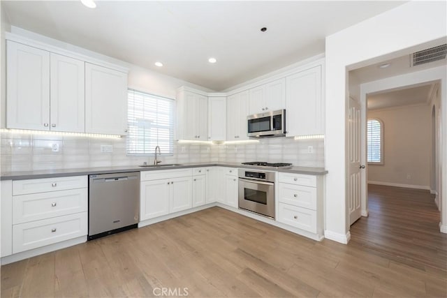 23 Bower Tree, Irvine, CA 92603 - kitchen with stainless steel appliances, plenty of natural light, light wood-type flooring, white cabinets, and recessed lighting