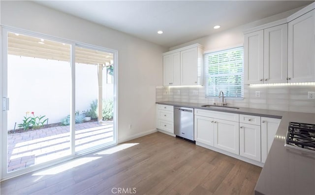 23 Bower Tree, Irvine, CA 92603 - kitchen with appliances with stainless steel finishes, light wood finished floors, backsplash, recessed lighting, and white cabinets