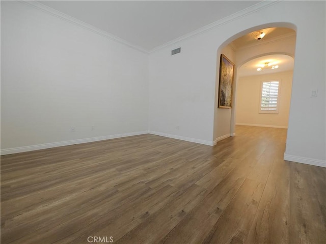 23 Bower Tree, Irvine, CA 92603 - unfurnished room featuring arched walkways, wood finished floors, and crown molding
