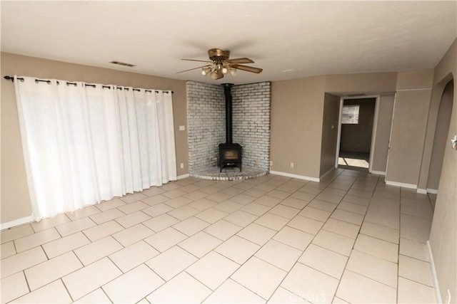 906 E 22nd St, Merced, CA 95340 - unfurnished living room featuring a wood stove, a ceiling fan, and light tile patterned floors