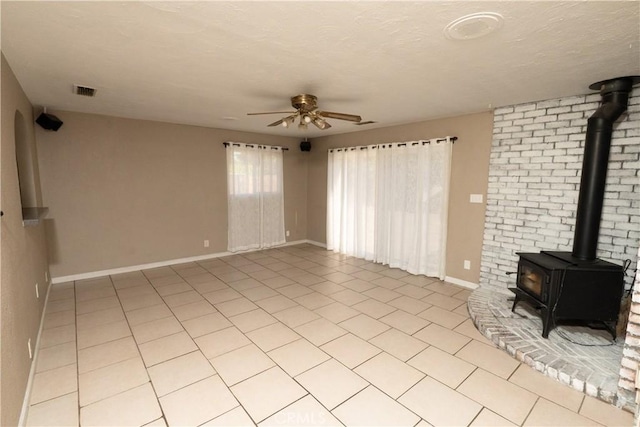 906 E 22nd St, Merced, CA 95340 - unfurnished living room featuring a wood stove, a ceiling fan, and light tile patterned floors