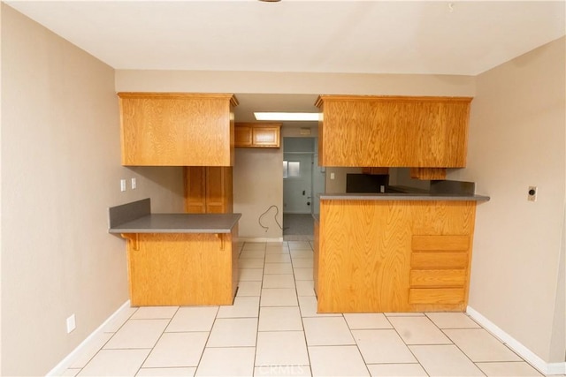 906 E 22nd St, Merced, CA 95340 - kitchen featuring a peninsula, a kitchen bar, and light tile patterned floors