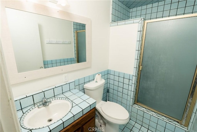 906 E 22nd St, Merced, CA 95340 - bathroom with tile walls, a shower stall, vanity, wainscoting, and tile patterned flooring