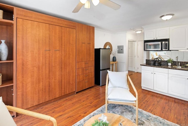1021 Scott St Unit 130, Point Loma, CA 92106 - kitchen with appliances with stainless steel finishes, ornamental molding, ceiling fan, electric panel, and light wood-type flooring