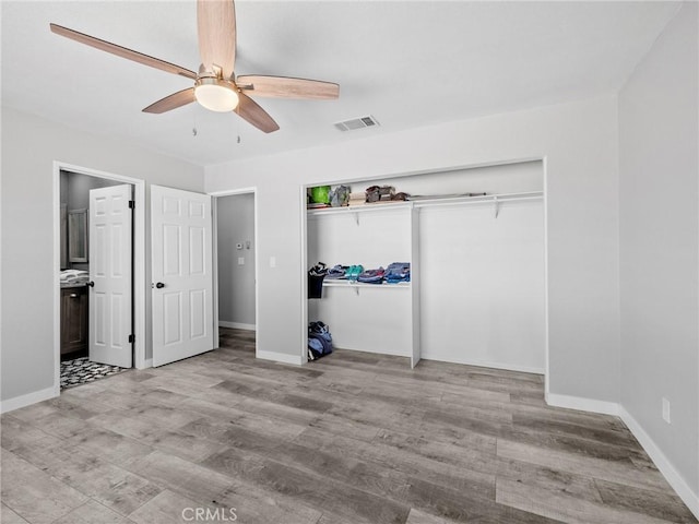 1233 Cabrillo Dr, Barstow, CA 92311 - unfurnished bedroom featuring wood finished floors, ceiling fan, a closet, and connected bathroom