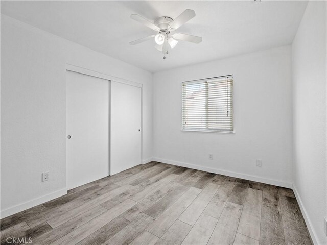 1233 Cabrillo Dr, Barstow, CA 92311 - unfurnished bedroom featuring a closet, wood finished floors, and a ceiling fan