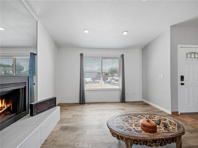 1233 Cabrillo Dr, Barstow, CA 92311 - living room featuring a tile fireplace, recessed lighting, a textured ceiling, and wood finished floors