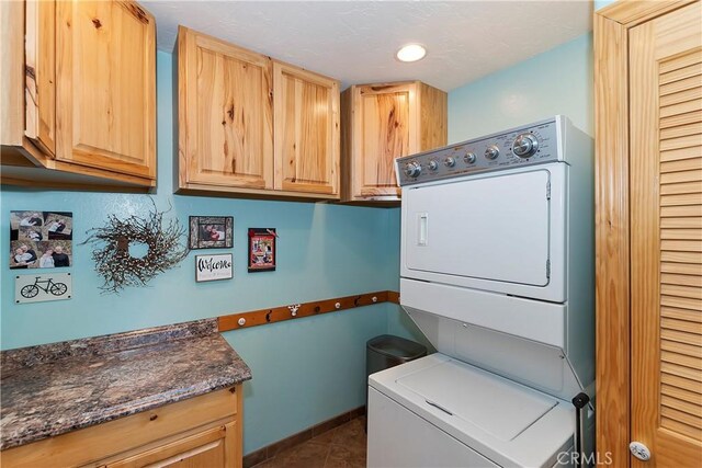 292 Heliotrope Dr, Lake Arrowhead, CA 92352 - laundry area featuring stacked washing machine and dryer, cabinet space, dark tile patterned floors, and recessed lighting