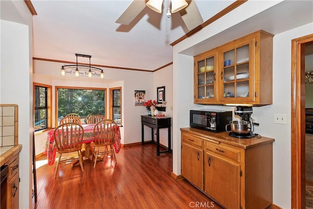 292 Heliotrope Dr, Lake Arrowhead, CA 92352 - dining room with dark wood finished floors, ceiling fan, and ornamental molding