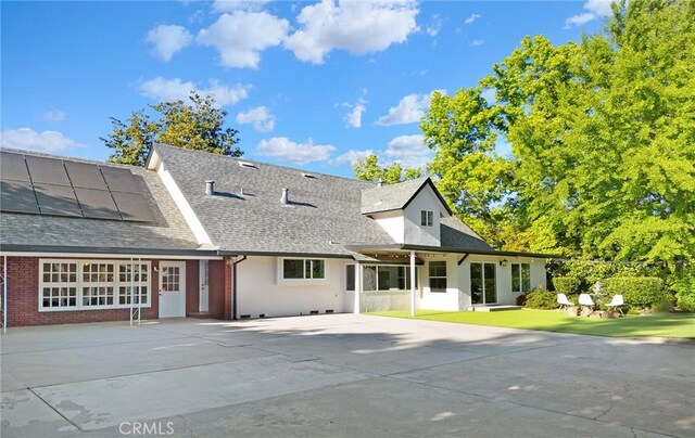 1785 Durham Dayton, Durham, CA 95938 - rear view of property featuring a shingled roof, roof mounted solar panels, brick siding, and concrete driveway