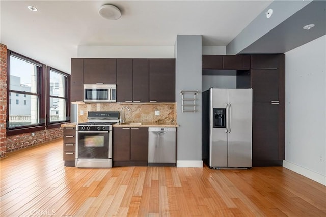 460 S Spring St Unit 1013, Los Angeles, CA 90013 - kitchen featuring stainless steel appliances, light countertops, light wood-style floors, dark brown cabinets, and backsplash