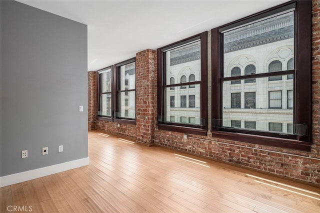 460 S Spring St Unit 1013, Los Angeles, CA 90013 - unfurnished room featuring wood finished floors and brick wall