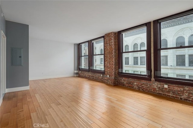 460 S Spring St Unit 1013, Los Angeles, CA 90013 - unfurnished living room with electric panel, light wood-type flooring, and brick wall