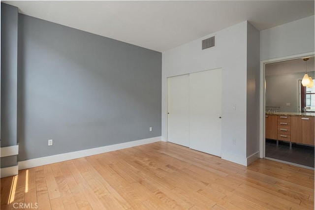 460 S Spring St Unit 1013, Los Angeles, CA 90013 - unfurnished bedroom with light wood finished floors and a closet