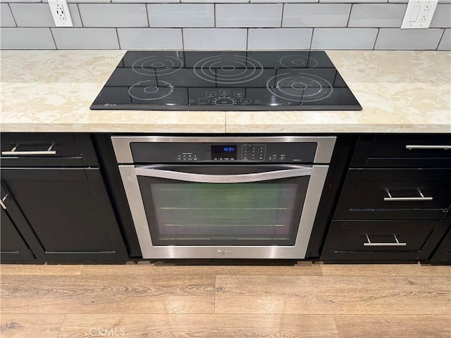 1319 E Monroe Ave, Orange, CA 92867 - kitchen featuring stainless steel oven, black electric cooktop, dark cabinetry, and decorative backsplash