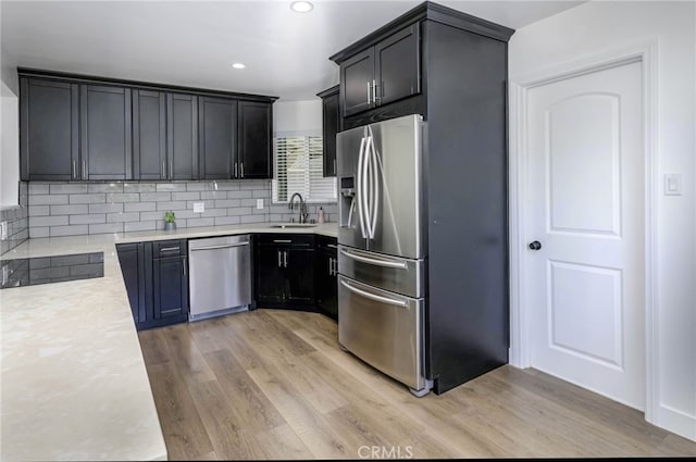 1319 E Monroe Ave, Orange, CA 92867 - kitchen featuring appliances with stainless steel finishes, light wood-style flooring, light countertops, tasteful backsplash, and recessed lighting