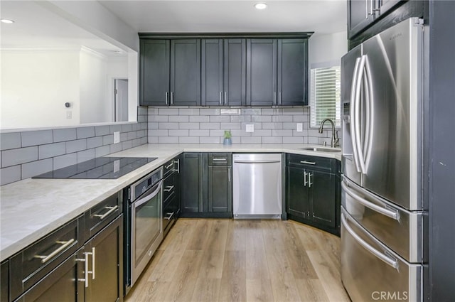 1319 E Monroe Ave, Orange, CA 92867 - kitchen with appliances with stainless steel finishes, light wood-type flooring, decorative backsplash, light countertops, and recessed lighting