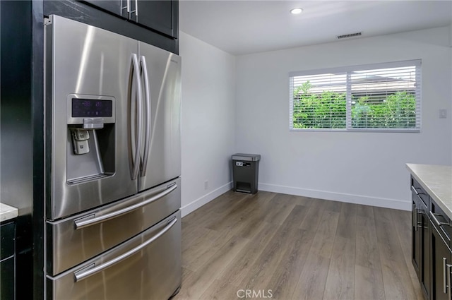 1319 E Monroe Ave, Orange, CA 92867 - kitchen featuring stainless steel fridge with ice dispenser, light countertops, light wood-style flooring, dark cabinetry, and recessed lighting