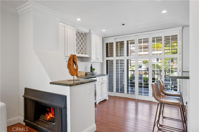 555 Esplanade Unit 320, Redondo Beach, CA 90277 - kitchen featuring dark countertops, white cabinetry, wood finished floors, recessed lighting, and ornamental molding