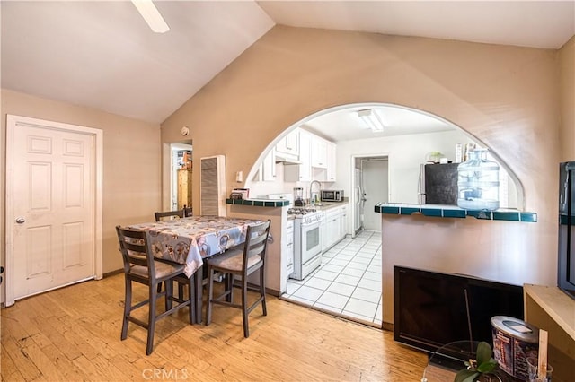 4430 W 166th St, Lawndale, CA 90260 - dining area with vaulted ceiling, arched walkways, light wood-style flooring, and a ceiling fan