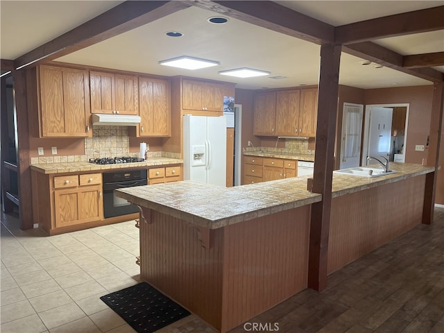 28957 Glen Oaks Dr, Menifee, CA 92586 - kitchen with white refrigerator with ice dispenser, black oven, under cabinet range hood, tasteful backsplash, and light countertops