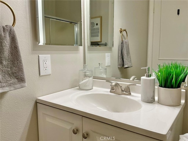 22801 Nolan St, Lake Forest, CA 92630 - bathroom featuring vanity, a textured wall, and a shower with shower door