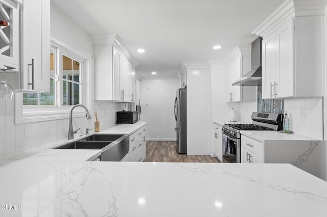 9818 Firebird Ave, Whittier, CA 90605 - kitchen featuring wall chimney exhaust hood, appliances with stainless steel finishes, recessed lighting, wood finished floors, and white cabinets