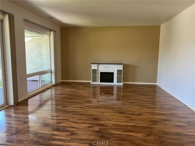 2268 Via Puerta Unit O, Laguna Woods, CA 92637 - unfurnished living room featuring dark wood-style floors and a brick fireplace